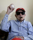 FILE - In this April 25, 2012 file photo, Conrado Marrero holds up a baseball as he poses for pictures during an interview in Havana, Cuba. Family members say Conrado Marrero, the oldest living former Major League Baseball player, has died in Havana. He was 102, just two days short of his 103rd birthday. Grandson Rogelio Marrero confirmed the death Wednesday afternoon, April 23, 2014. (AP Photo/Franklin Reyes, File)