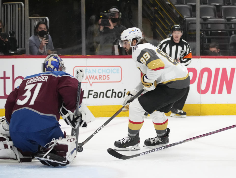 Colorado Avalanche goaltender Philipp Grubauer, left, stops a shot by Vegas Golden Knights right wing Alex Tuch during the first period of Game 5 of an NHL hockey Stanley Cup second-round playoff series Tuesday, June 8, 2021, in Denver. (AP Photo/David Zalubowski)