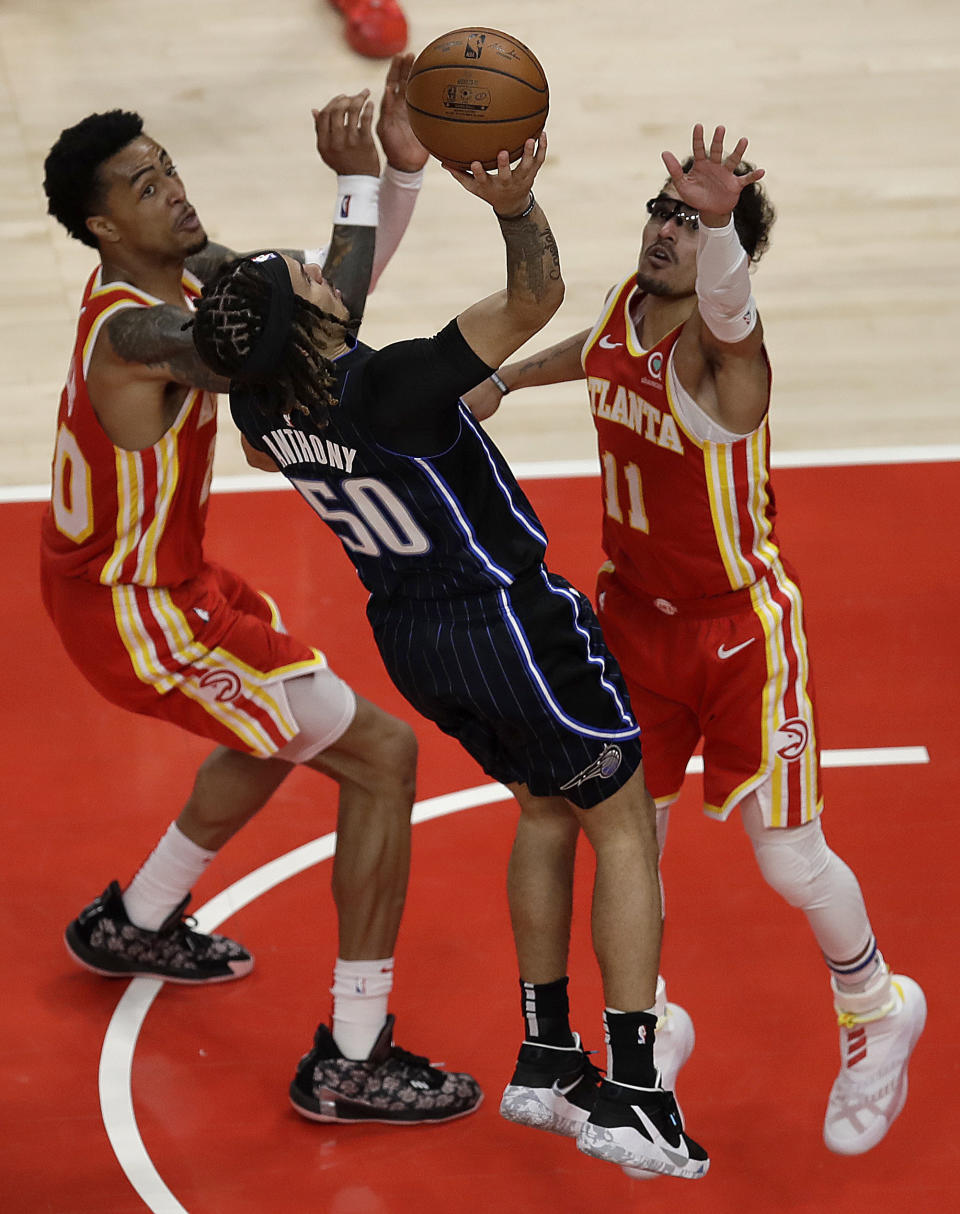 Orlando Magic guard Cole Anthony, center, shoots against Atlanta Hawks' Trae Young, right, during the second half of an NBA basketball game Tuesday, April 20, 2021, in Atlanta. (AP Photo/Ben Margot)