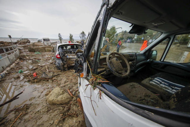 Damaged vehicles are seen on the sea front after heavy rainfall triggered landslides that collapsed buildings and left as many as 12 people missing, in Casamicciola, on the southern Italian island of Ischia, Saturday, Nov. 26, 2022. Firefighters are working on rescue efforts as reinforcements are being sent from nearby Naples, but are encountering difficulties in reaching the island either by motorboat or helicopter due to the weather. (AP Photo/Salvatore Laporta)
