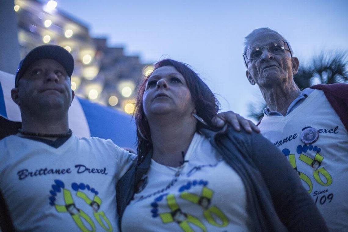 Dawn Drexel gets support from boyfriend James Dean, (left), and missing teen’s great step-grandfather, James Richardson, right. Brittanee Marie Drexel, age 17, went missing April, 25, 2009. Her family, friends and supportors, held a vigil for the 6-year anniversary of the missing girl, walking her last known path from the Bar Harbor Hotel to the Blue Water Resort concluding with a slide show of her life and a candle light vigil at Hurl Rock Park.