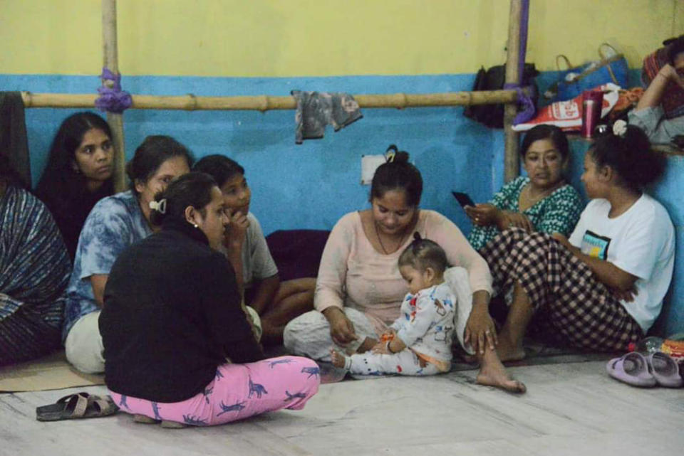 Women and children sit at a relief camp after flash floods triggered by a sudden heavy rainfall swamped the Rangpo town in Sikkim, India, Thursday, Oct.5. 2023. The flooding took place along the Teesta River in the Lachen Valley of the north-eastern state, and was worsened when parts of a dam were washed away. (AP Photo/Prakash Adhikari)