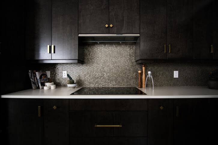 <em>Dalam desain dapur minimalis 2×2 bergaya maskulin ini, tema warna utama yang dipakai hanya abu-abu gelap dan hitam. (Foto: Unsplash – Christian Mackie)</em>