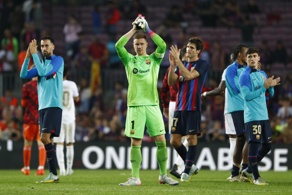 Barcelona's Sergio Busquets, left, and Barcelona's goalkeeper Marc-Andre ter Stegen applauds fans at the end of the Champions League Group C soccer match between Barcelona and Bayern Munich at the Camp Nou stadium in Barcelona, Spain, Wednesday, Oct. 26, 2022. (AP Photo/Joan Monfort)