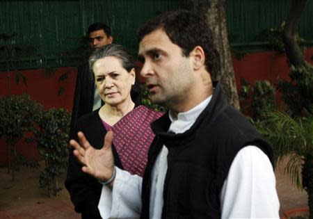 Chief of India's ruling Congress party Sonia Gandhi (L) watches as her son, lawmaker Rahul Gandhi speaks during a news conference in New Delhi December 8, 2013. REUTERS/Stringer