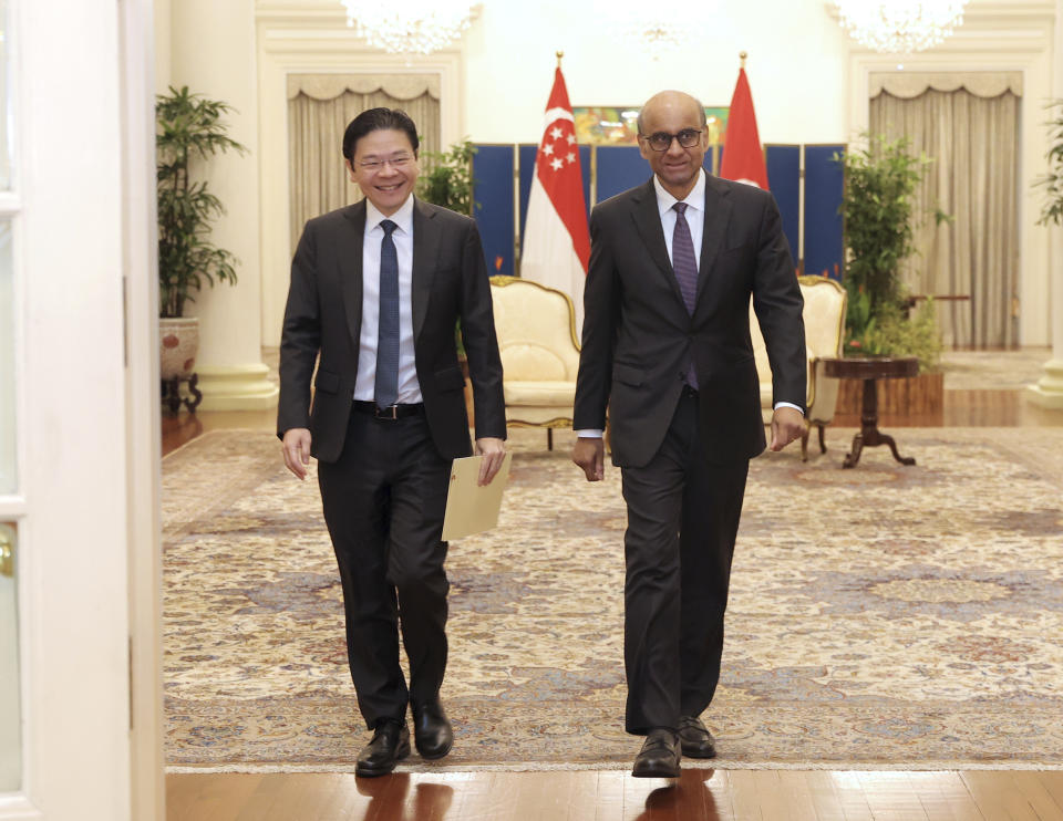In this photo released by Singapore's Ministry of Communications and Information, Singapore President Tharman Shanmugaratnam, right, walk with Singapore's Deputy Prime Minister Lawrence Wong at the Istana in Singapore, Monday, May 13, 2024. (Mohd Fyrol/Ministry of Communications and Information via AP)