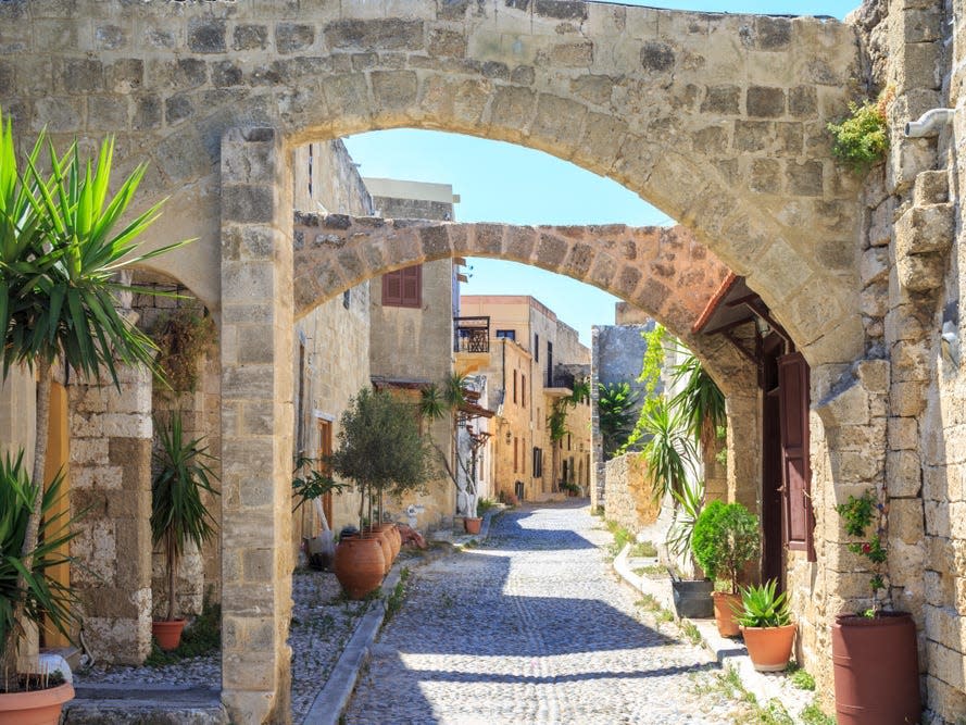 Cobblestone streets and old buildings lined with plants.