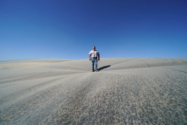 Dairy farmer Joey Airoso stands on top of a methane collecting dome that covers one of his farm's waste collecting ponds in Pixley, California