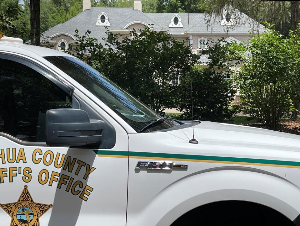 The vehicle of an investigator from the Alachua County Sheriff's Office is parked May 4 outside the home of Paul O. Reinhart, 46, of Gainesville, after Reinhart was suspected of killing his two young sons and then himself at the family's vacation home 50 miles away in Cross City. One of Reinhart's sons, 11-year-old Brody, was regularly a bat boy for the No. 10-ranked University of Florida baseball team.