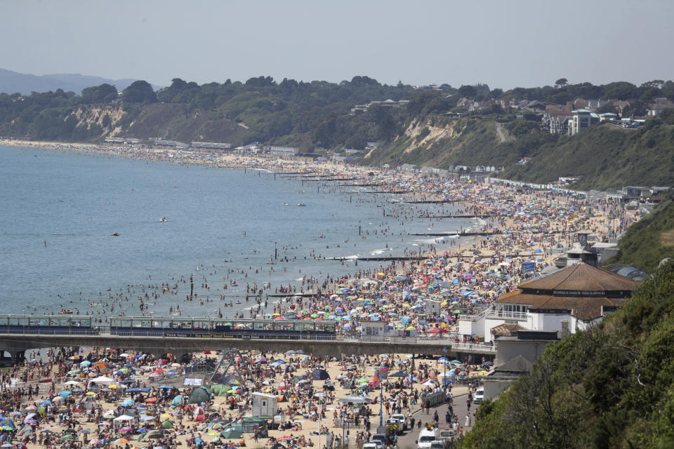 Crowds gather as hot weather draws crowds to the beach in Bournemouth, England, Thursday June 25, 2020. Coronavirus lockdown restrictions are being relaxed but people should still respect the distancing requirements between family groups. According to weather forecasters this could be the UK's hottest day of the year, so far, with scorching temperatures forecast to rise even further. (Andrew Matthews/PA via AP)