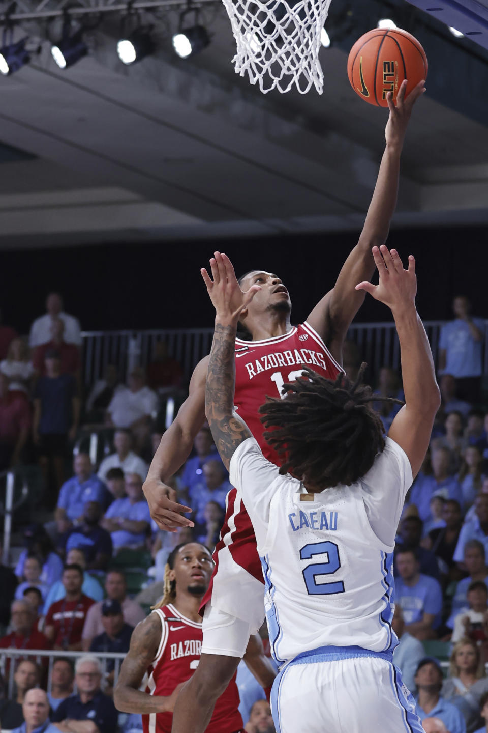 In a photo provided by Bahamas Visual Services, Arkansas' Tramon Mark goes for a lay up over Elliot Cadeau during the first half of an NCAA college basketball game in the Battle 4 Atlantis at Paradise Island, Bahamas, Friday, Nov. 24, 2023. (Tim Aylen/Bahamas Visual Services via AP)