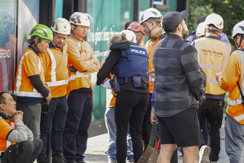 Police interview construction workers in the central business district following a shooting in Auckland, New Zealand, Thursday, July 20, 2023. A gunman killed and injured people at a construction site in New Zealand’s largest city, as the nation prepared to host games in the FIFA Women’s World Cup soccer tournament, authorities said. It wasn’t immediately clear if police had shot the gunman or he had killed himself. (Jason Oxenham/New Zealand Herald via AP)