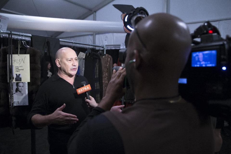 Designer Carmen Marc Valvo speaks to the media backstage before his fall 2014 collection is modeled during Fashion Week, Friday, Feb. 7, 2014, in New York. (AP Photo/John Minchillo)