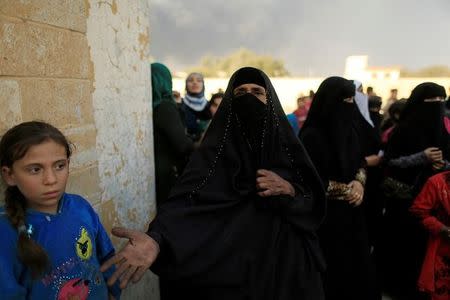 A newly displaced woman, who had climbed over a wall to get humanitarian packages, reacts at a processing center in Qayyara, south of Mosul, Iraq October 25, 2016. REUTERS/Zohra Bensemra