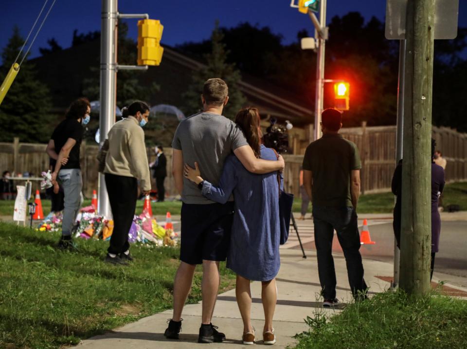 People gather at a makeshift memorial after four members of a family were struck by a truck and killed in London, Ontario (Carlos Osorio/Reuters)