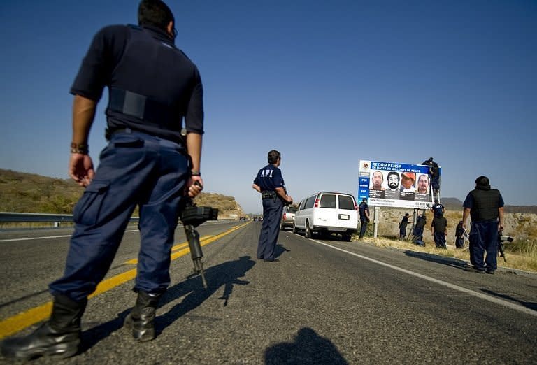 File picture shows Mexican law enforcement officers putting up a billboard with pictures of the heads of the La Familia drug cartel. Mexican police have captured La Famila's top boss in a raid on the central town of Aguascalientes, a government spokesman said