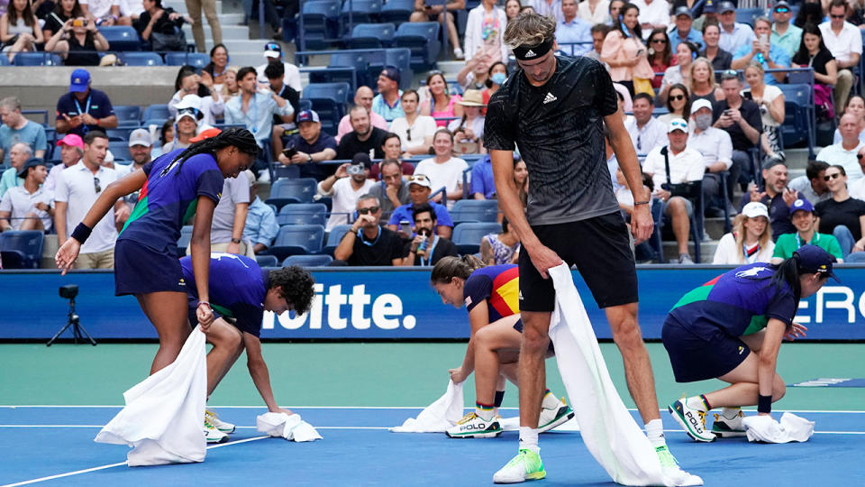 Alexander Zverev, pictured here helping dry the court during his US Open quarter-final clash with Lloyd Harris.