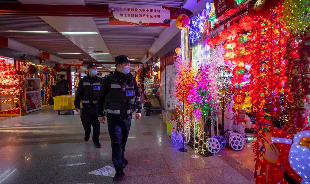 File photo: Police officers patrol inspect Christmas and New Year decorations in Yiwu, China, 11 December 2020 (EPA-EFE)