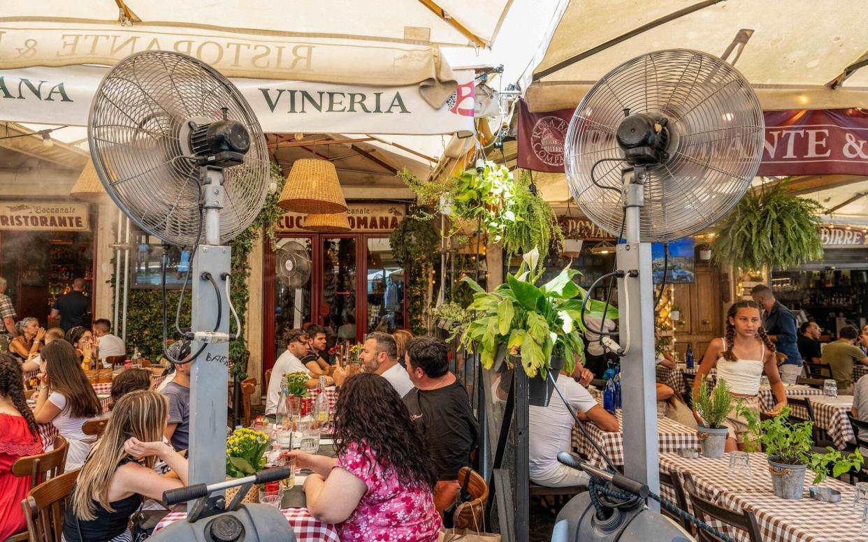 Misting fans cool down customers at a restaurant in Campo de' Fiori in Rome, Italy,