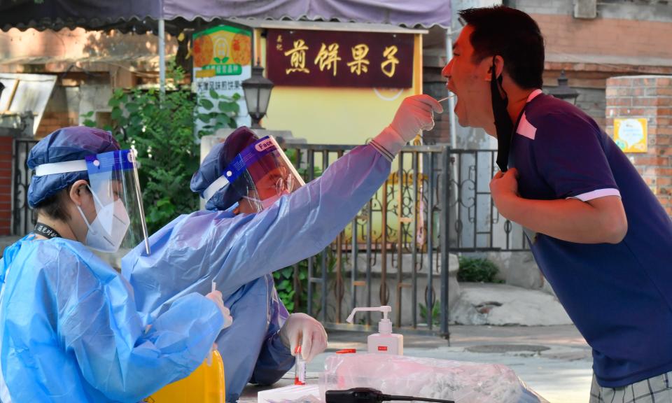 A medical worker takes a swab sample from a citizen for nucleic acid testing at Heping District in Tianjin, north China, July 24, 2022. (Photo by Sun Fanyue/Xinhua via Getty Images)