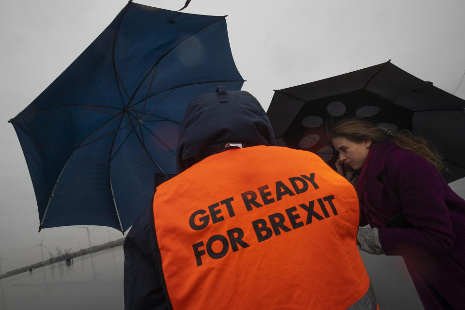 A spokesperson wears a safety vest during a press tour of an overflow parking lot for trucks after the Brexit transition period, in Hook of Holland, near Rotterdam, Netherlands, Monday, Dec. 21, 2020. The parking lot is being set up near Hook of Holland for trucks whose drivers have not filled in the necessary paperwork to get onto a ferry bound for England. (AP Photo/Peter Dejong)