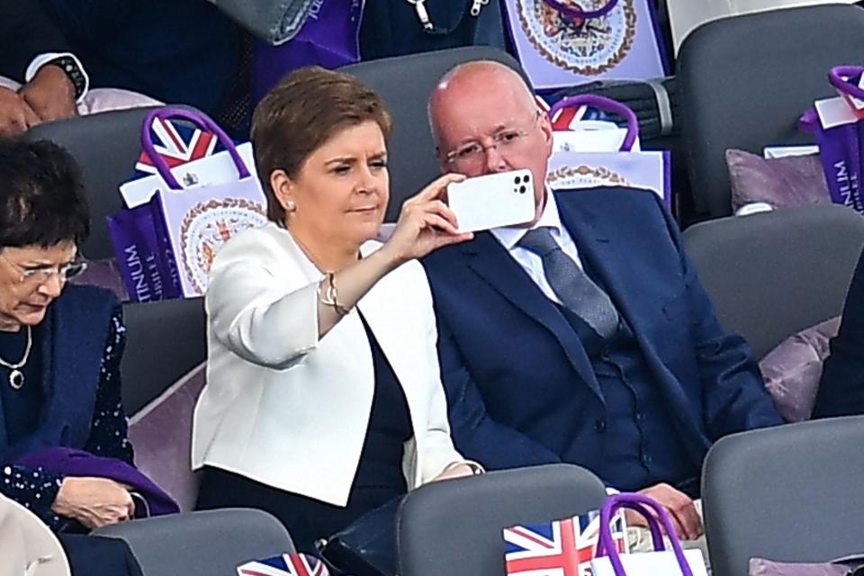 Scotland's First Minister Nicola Sturgeon and her husband and current chief executive officer of the Scottish National Party Peter Murrel take their seats for the Platinum Party (POOL/AFP via Getty Images)