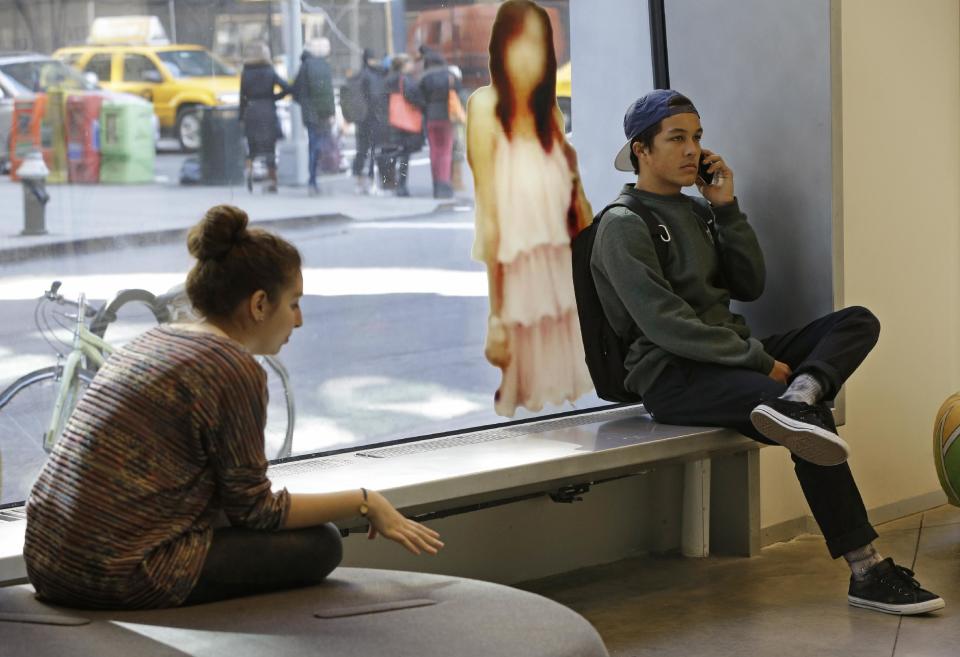 In this Tuesday, March 5, 2013, photo, Students relax beside an image of a young woman taken from "Google Maps,"as part of "The Public Private" exhibit at the Anna-Maria and Stephen Kellen Gallery in the Sheila C. Johnson Design Center at Parsons The New School for Design, in New York. The exhibit seeks to explore the boundaries and gray areas of online privacy, surveillance and data collection in the age of Facebook and Google. (AP Photo/Kathy Willens)