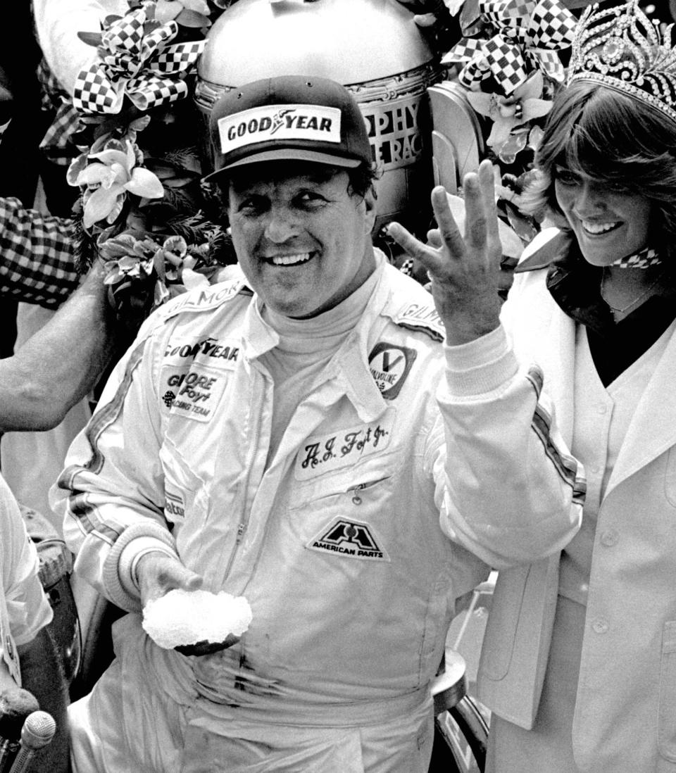 FILE - In this May 29, 1977, file photo, driver A.J. Foyt holds up four fingers in victory lane after winning his fourth Indianapolis 500 auto race at Indianapolis Motor Speedway in Indianapolis. pedestrians in Gasoline Alley or stopping to sign autographs. Yes, things are definitely different at his favorite racing venue. Even the seemingly indestructible 85-year-old, four-time Indianapolis 500 winner finds himself reluctantly wearing a mask and social distancing. (AP Photo/File)