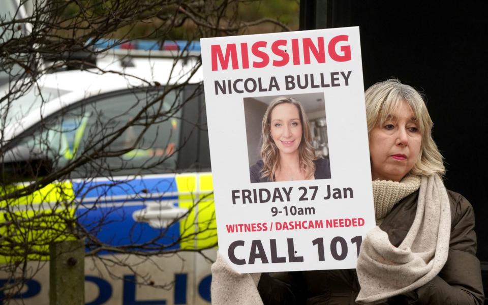 Friends of Ms Bulley hold missing person appeal posters 