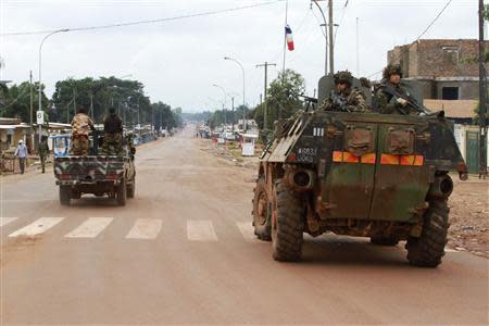 A French military vehicle patrols past Seleka soldiers during fighting between Muslim and Christian militias in Bangui December 6, 2013. REUTERS/Herve Serefio