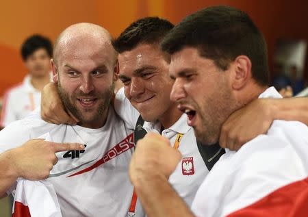 First placed Piotr Malachowski (L) of Poland and his third placed compatriot Robert Urbanek celebrate with their coach Maciej Wlodarczyk (C) after the men's discus throw final at the 15th IAAF World Championships at the National Stadium in Beijing, China, August 29, 2015. REUTERS/Dylan Martinez