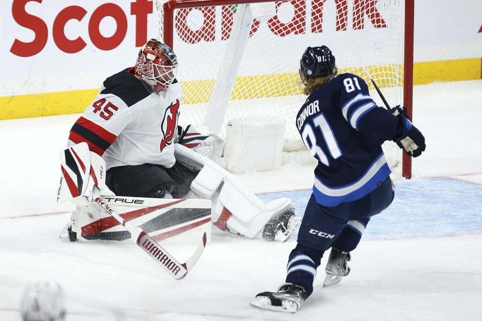 A shot by Winnipeg Jets' Kyle Connor is stopped by New Jersey Devils goaltender Jonathan Bernier (45) during the first period of an NHL hockey game Friday, Dec. 3, 2021, in Winnipeg, Manitoba. (John Woods/The Canadian Press via AP)