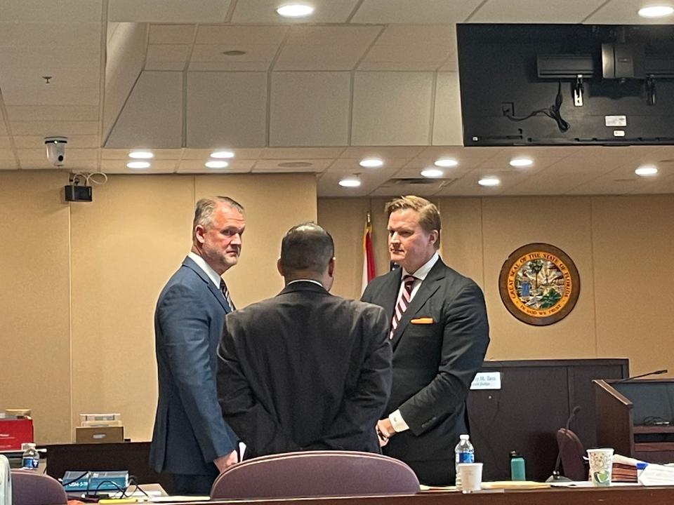 Defense lawyer Morris Carranza with his back turned.  John Spivey is to his left and Dr. John Fabian is on the right.