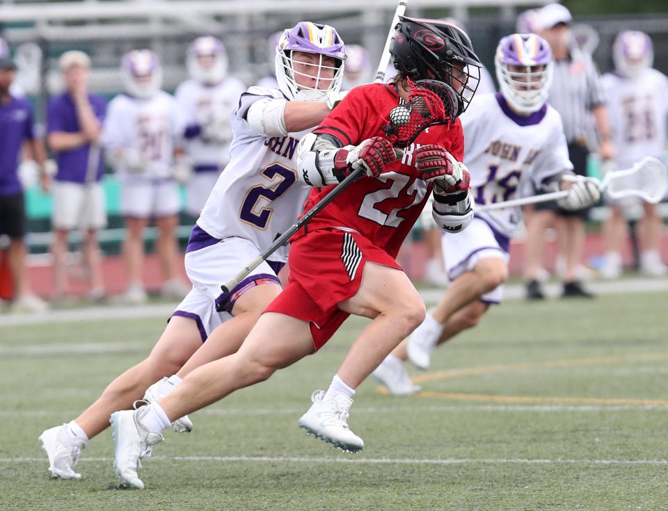 Rye's Tyler McDermott (22) turns the corner on John Jay's Luca Diva (2) during the Section 1 Class C championship at Yorktown High School May 29, 2024. Rye won the game 11-7.