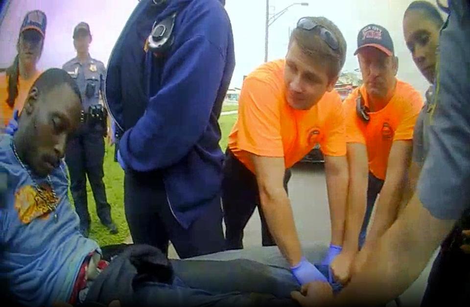 In this image made from a May 2019 body-worn camera video of Oklahoma City Police Officer Ashley Copeland, paramedics and police officers carry Derrick Elliot Scott onto a stretcher after he was arrested and went in and out of consciousness during the arrest in Oklahoma City.