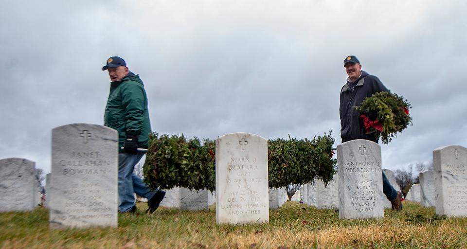 Doylestown American Legion Post 210 members Rick Fulginiti, left, and Ed O’Dwyer, carry a pole filled with wreaths that they gathered from the gravesites of veterans buried at Washington Crossing National Cemetery in Upper Makefield on Monday, Jan. 17, 2022.