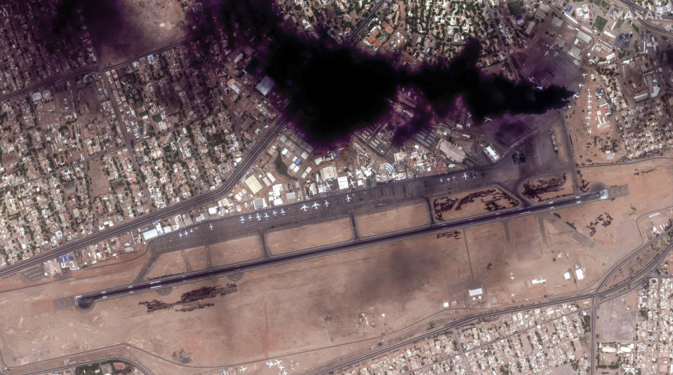 This satellite image provided by Maxar Technologies shows smoke rising from two burning planes at Khartoum International Airport, Sudan, Sunday April 16, 2023. The Sudanese military and a powerful paramilitary group are battling for control of the chaos-stricken nation for a second day. (Satellite image ©2023 Maxar Technologies via AP)