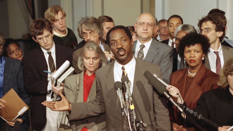 Charles Ogletree, lawyer for Anita Hill, speaks to reporters as Paul Minor, behind, looks outside the Caucus Room in the Russell Senate Office Building on Capitol Hill in Washington DC on Oct. 13, 1991. - John Duricka/AP
