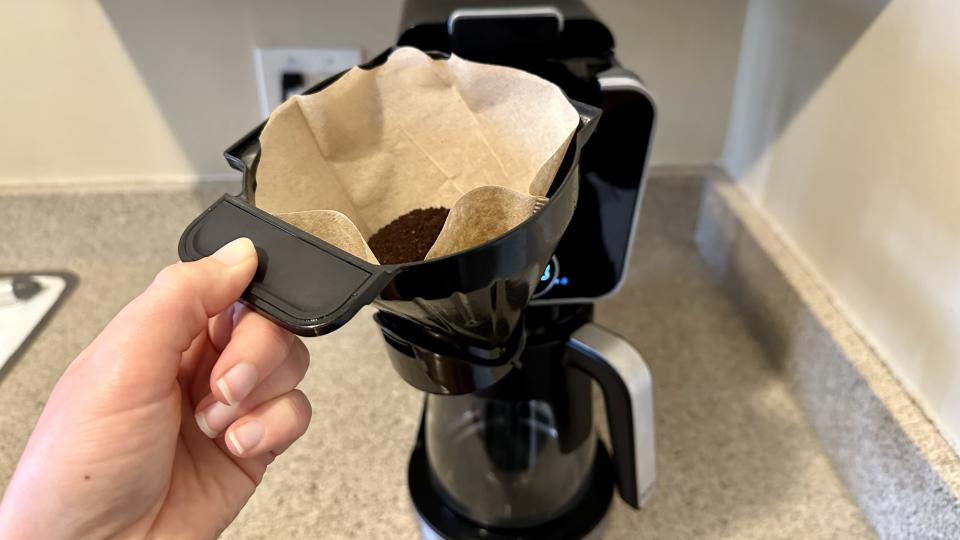 Removable brew basket with coffee grinds and filter