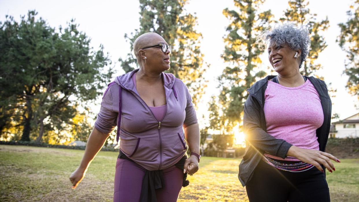 two black woman walking through a grass field