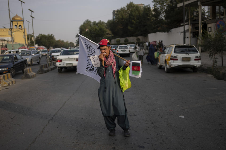 A street vendor sells Taliban and Afghan flags on a street in Kabul, Afghanistan, Thursday, Sept. 30, 2021. (AP Photo/Bernat Armangue)