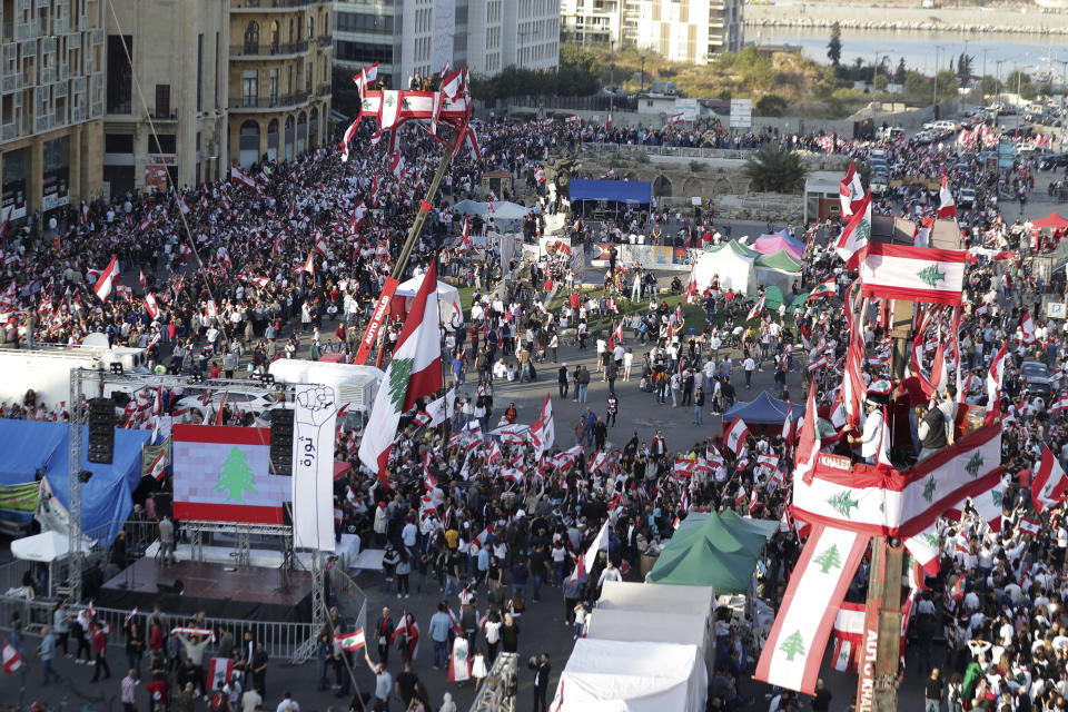 Anti-government protesters gather during separate civil parade at the Martyr square, in downtown Beirut, Lebanon, Friday, Nov. 22, 2019. Protesters gathered for their own alternative independence celebrations, converging by early afternoon on Martyrs' square in central Beirut, which used to be the traditional location for the official parade. Protesters have occupied the area, closing it off to traffic since mid-October. (AP Photo/Hassan Ammar)