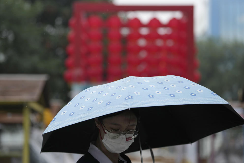 A woman uses an umbrella during a rainy day in Beijing, Sunday, Aug. 14, 2022. (AP Photo/Ng Han Guan)