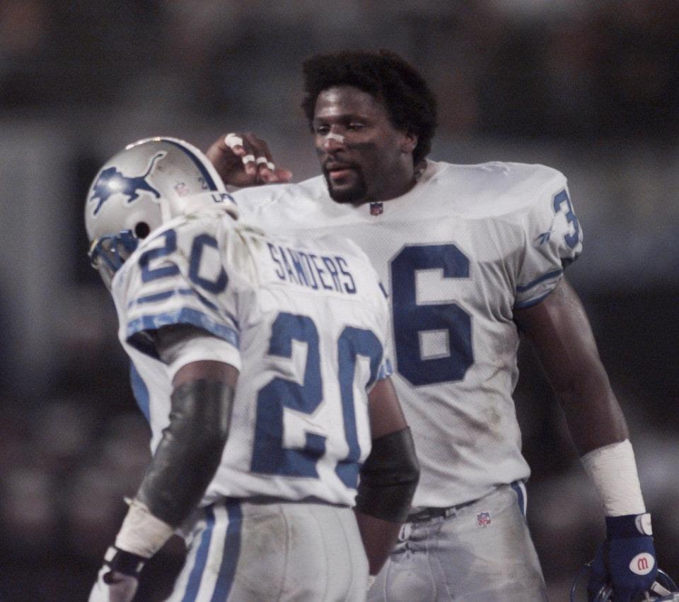 Lions safety Bennie Blades congratulates running back Barry Sanders during a game against the Chargers on Nov. 11, 1996, in San Diego.