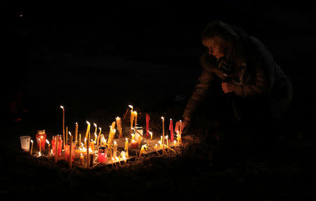 A woman lights candles at a march on the first anniversary of the murder of opposition Serb politician Oliver Ivanovic, in Belgrade, Serbia January 16, 2019. The murder happened in the town of Mitrovica in Kosovo. REUTERS/Kevin Coombs