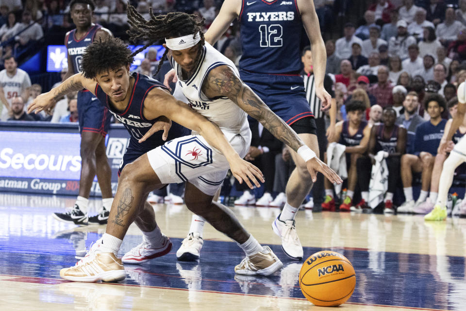 Dayton guard Javon Bennett (0) and Richmond guard DeLonnie Hunt (3) go after a loose ball during the first half of an NCAA college basketball game on Saturday, Jan. 27, 2024 in Richmond, Va. (AP Photo/Shaban Athuman)