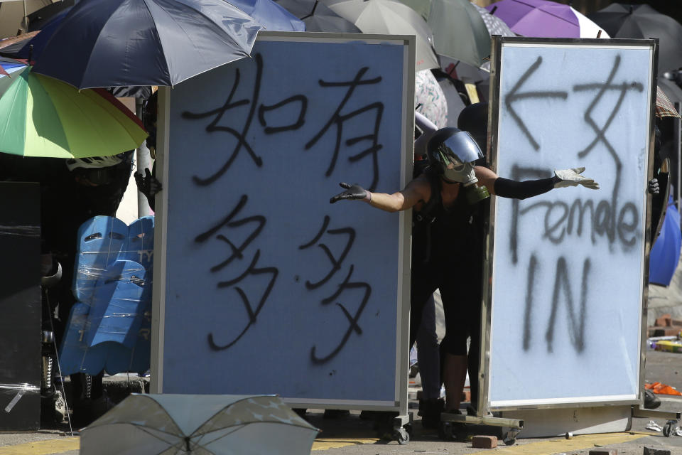 A protestor gestures from behind barricades during a confrontation with police at the Hong Kong Polytechnic University in Hong Kong, Sunday, Nov. 17, 2019. (AP Photo/Achmad Ibrahim)