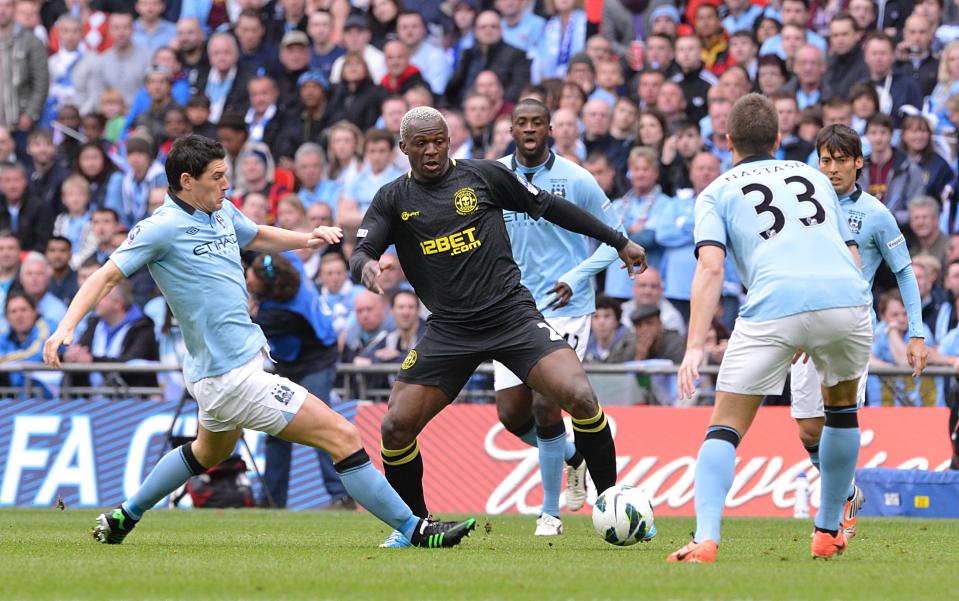 Wigan Athletic's Arouna Kone (centre) and Manchester City's Gareth Barry battle for the ball