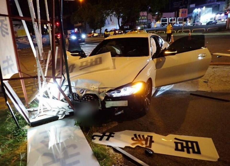 台中市昨日發生ＢＭＷ跑車與計程車碰撞，ＢＭＷ跑車撞上廣告招牌，車頭受損頗嚴重。（記者陳金龍翻攝）