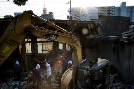 Kurdish workers discuss their next steps at a demolition site in Chiba east of Tokyo, October 21, 2015. REUTERS/Thomas Peter